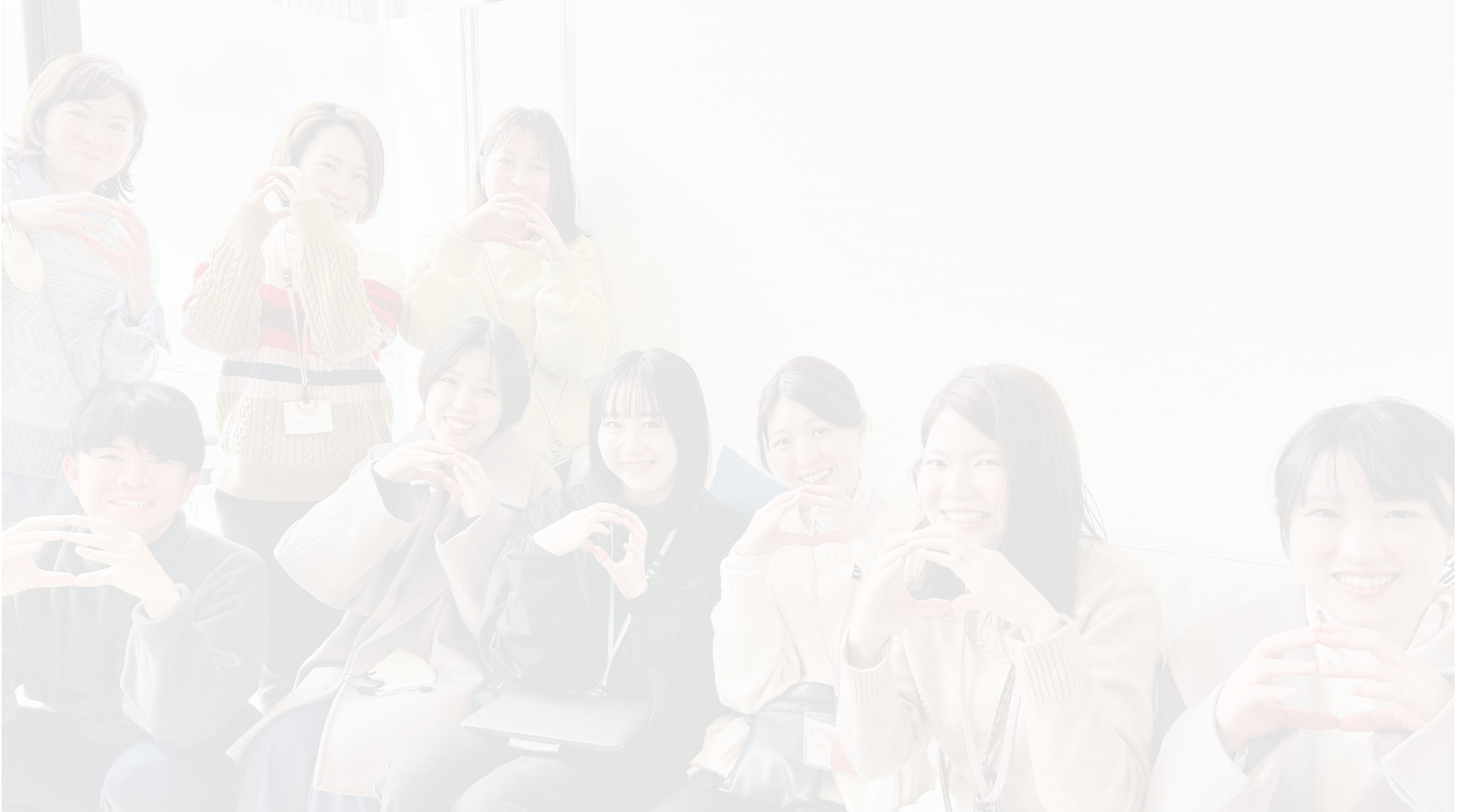 9人の若者が両手で丸を作っている写真