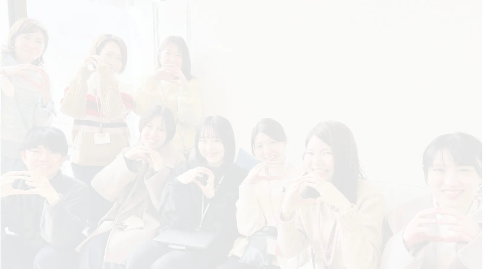 9人の若者が両手で丸を作っている写真